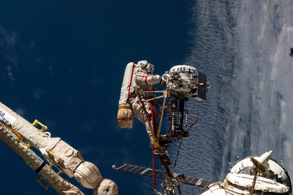 Cosmonaut in spacesuit working on International Space Station exterior during spacewalk operation