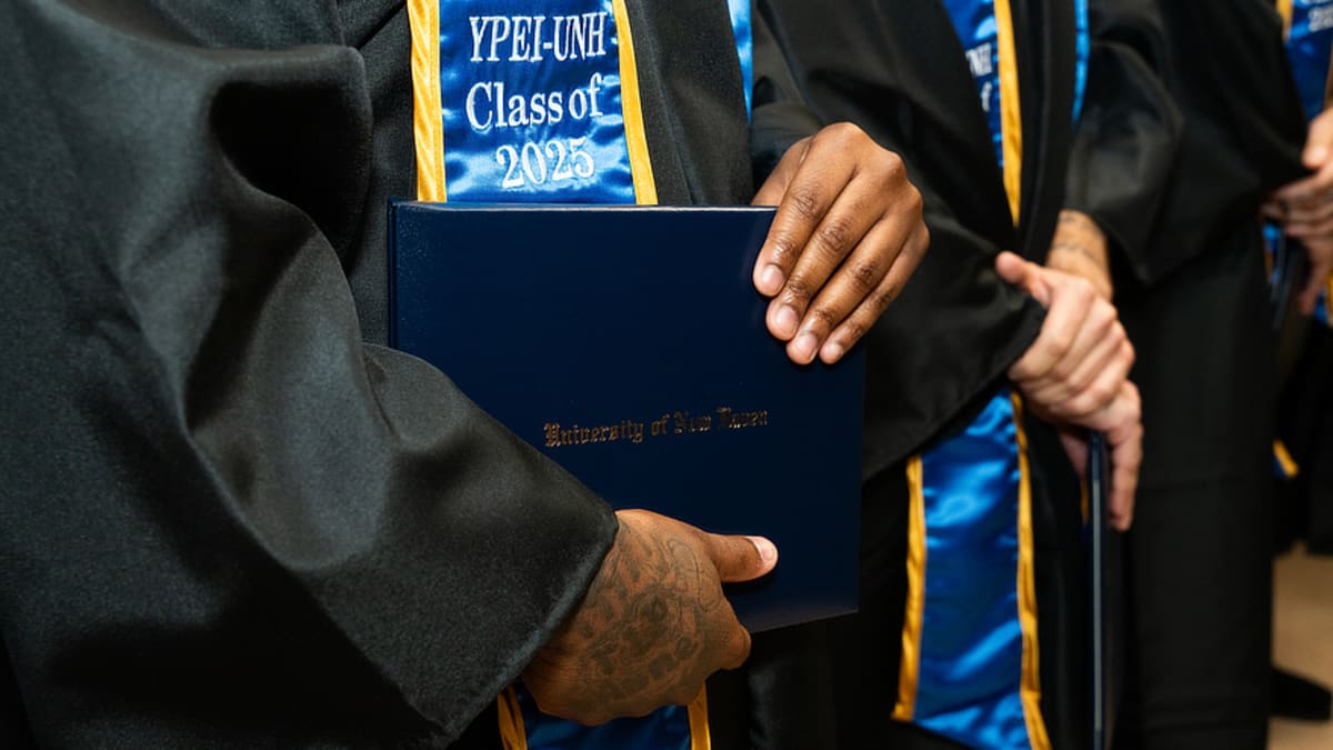 College students studying and discussing coursework together in a classroom setting inside a correctional facility