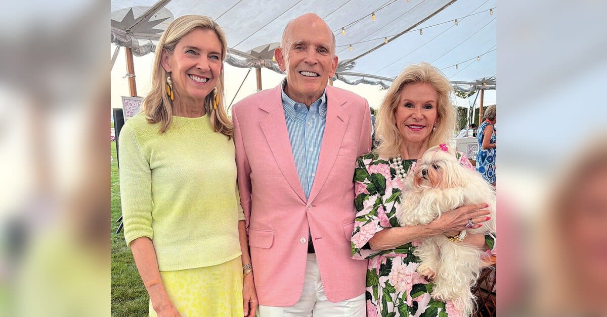 Supporters holding rescued puppy at outdoor summer fundraiser event for Potter League for Animals