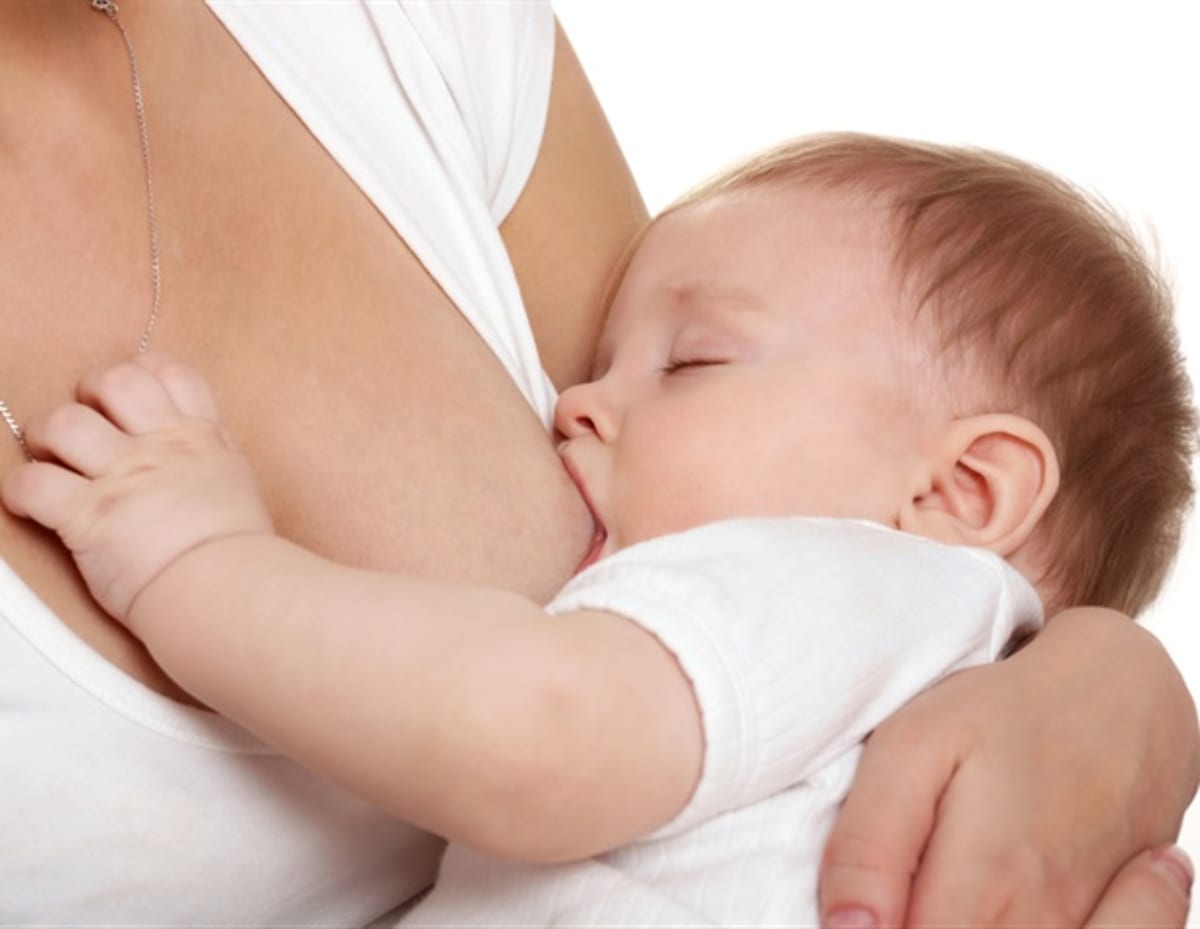 Mother breastfeeding infant while researchers study biological markers in child health laboratory