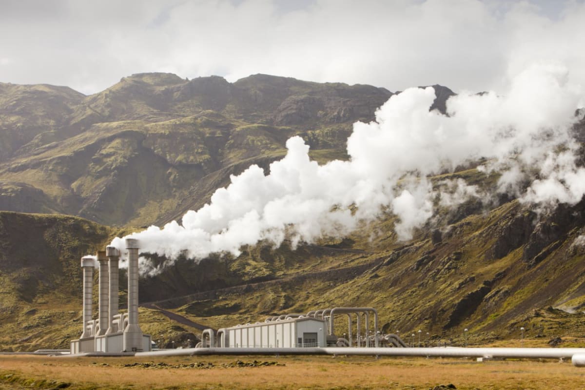 Geothermal power station with steam rising against mountain landscape in Iceland's volcanic region