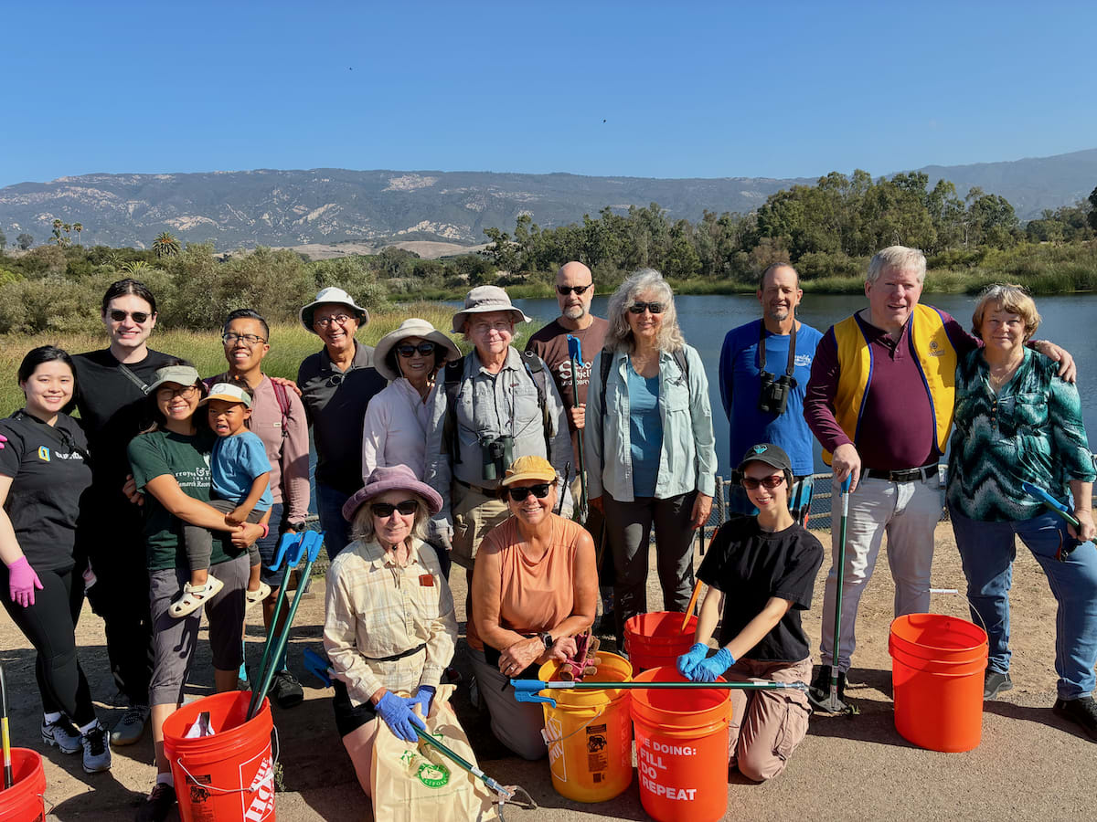 Large group of volunteers in bright shirts gathered together after Santa Barbara coastal cleanup event