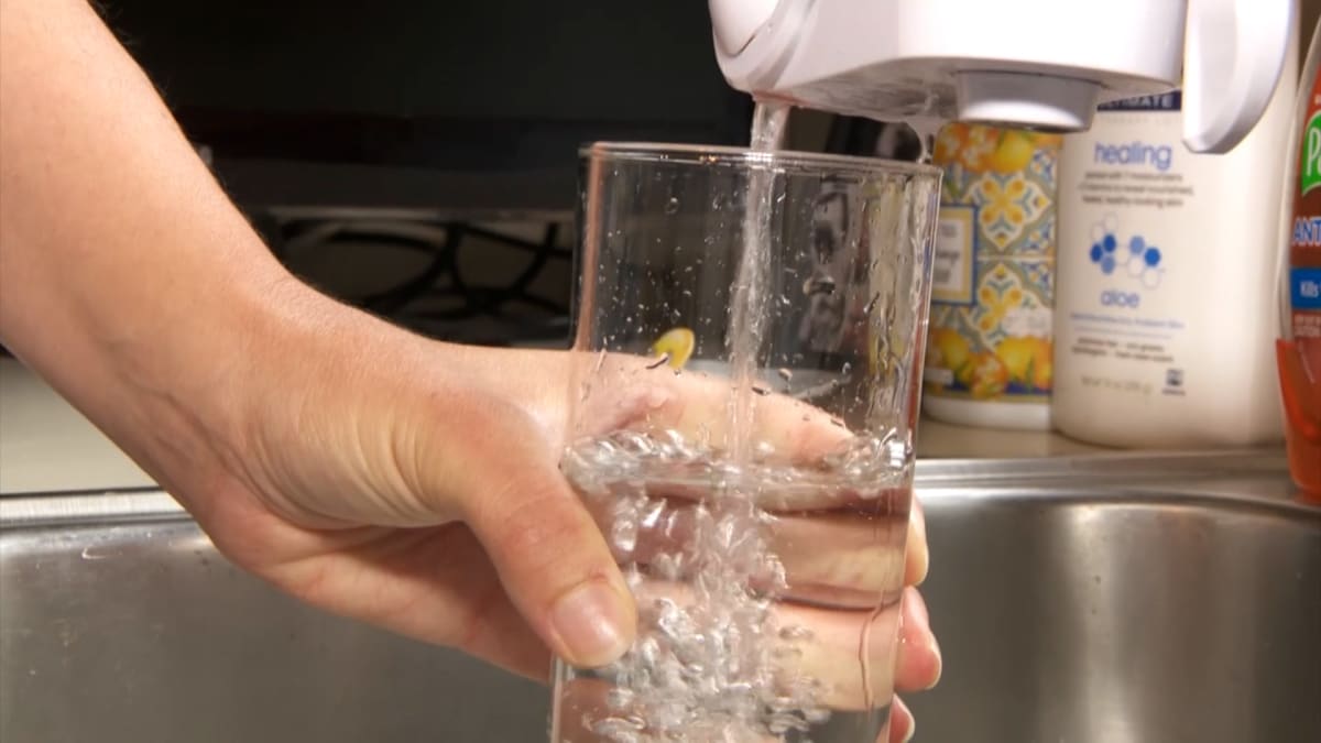 Clean drinking water flowing from kitchen tap into glass in New Jersey home