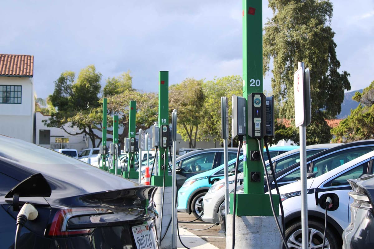 Electric vehicle charging at home station with modern residential house in background