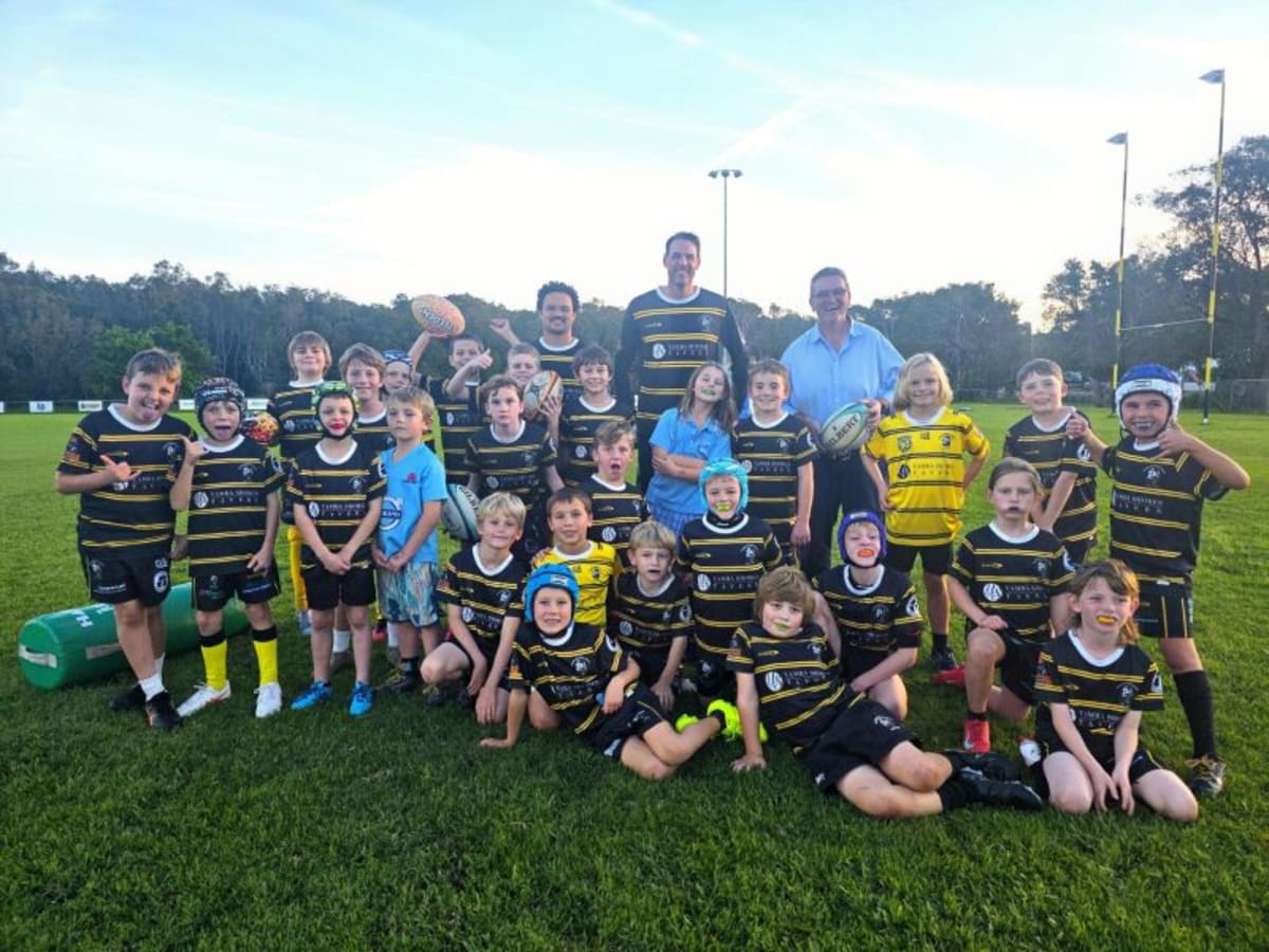 Young diverse students playing Rugby 7s on grass field in Australian regional community
