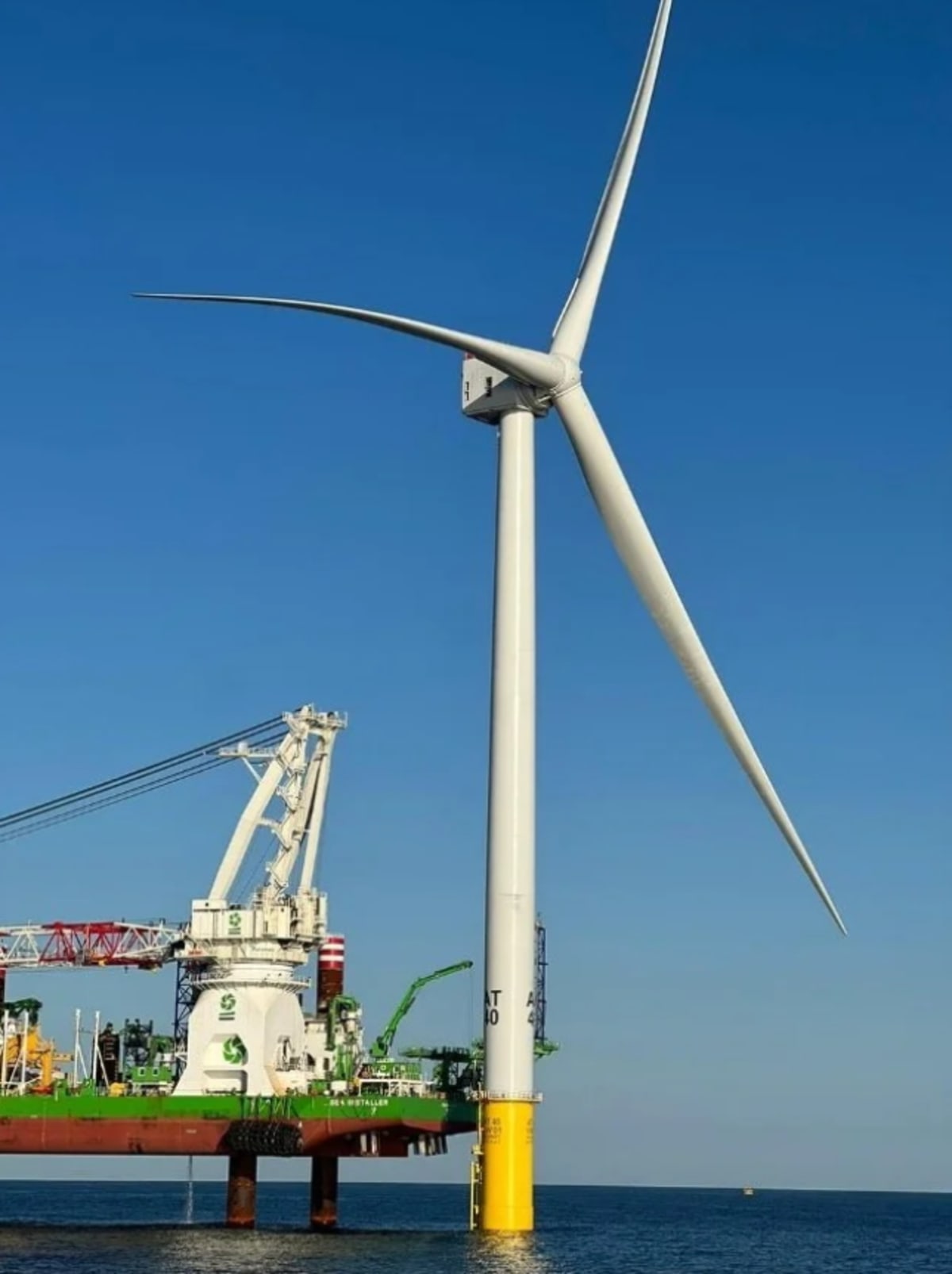 Massive offshore wind turbines standing in ocean waters off Massachusetts coast generating clean energy