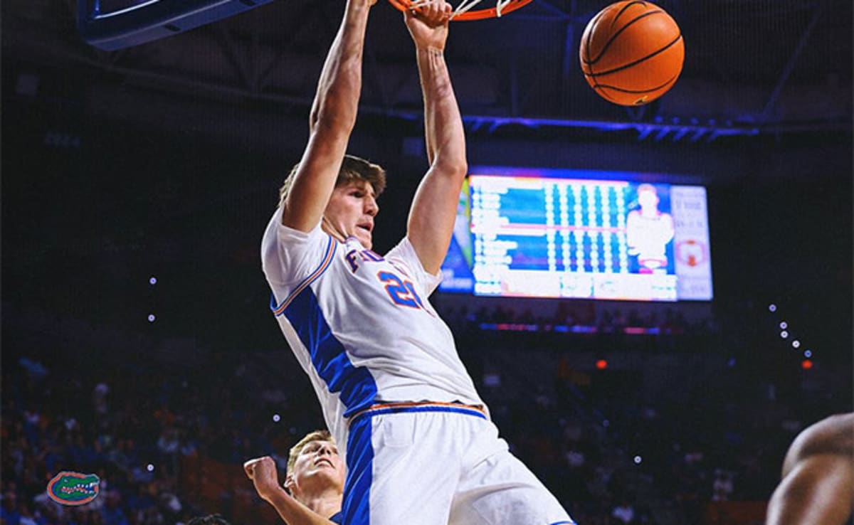 Florida Gators basketball players celebrating SEC championship victory on home court with fans cheering