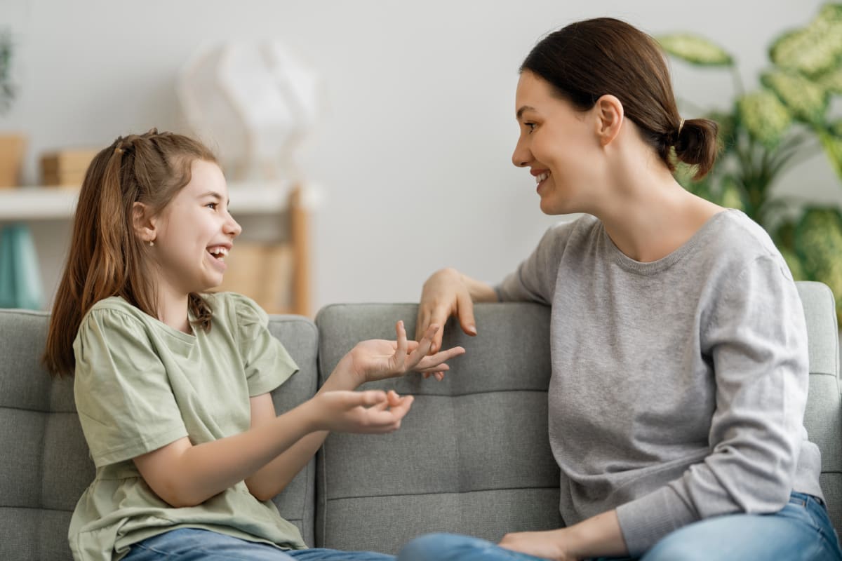 ** Parent and young child having a conversation together at home, practicing communication skills
