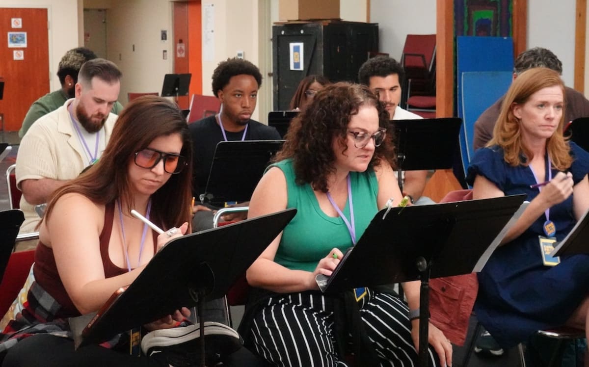 Cast members from Come From Away musical performing ensemble scene at Orlando Shakes theater