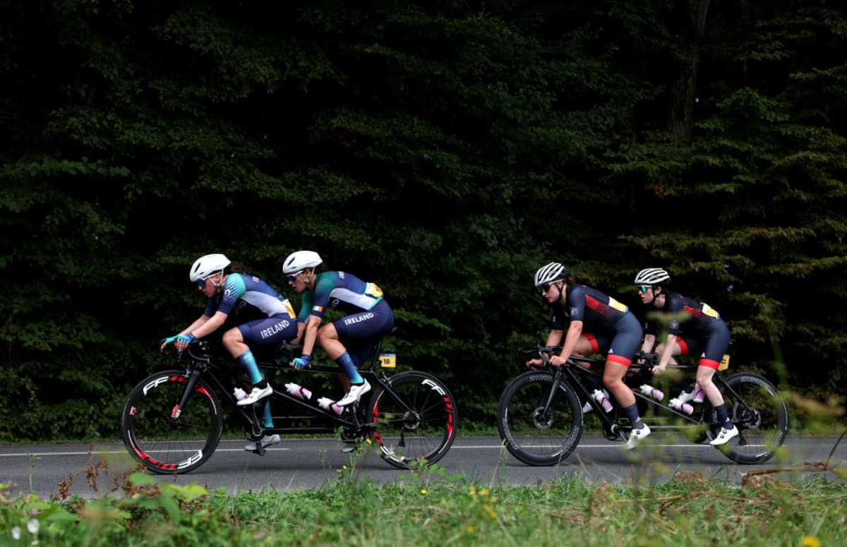 Para cyclists racing on road bikes during competitive time trial event