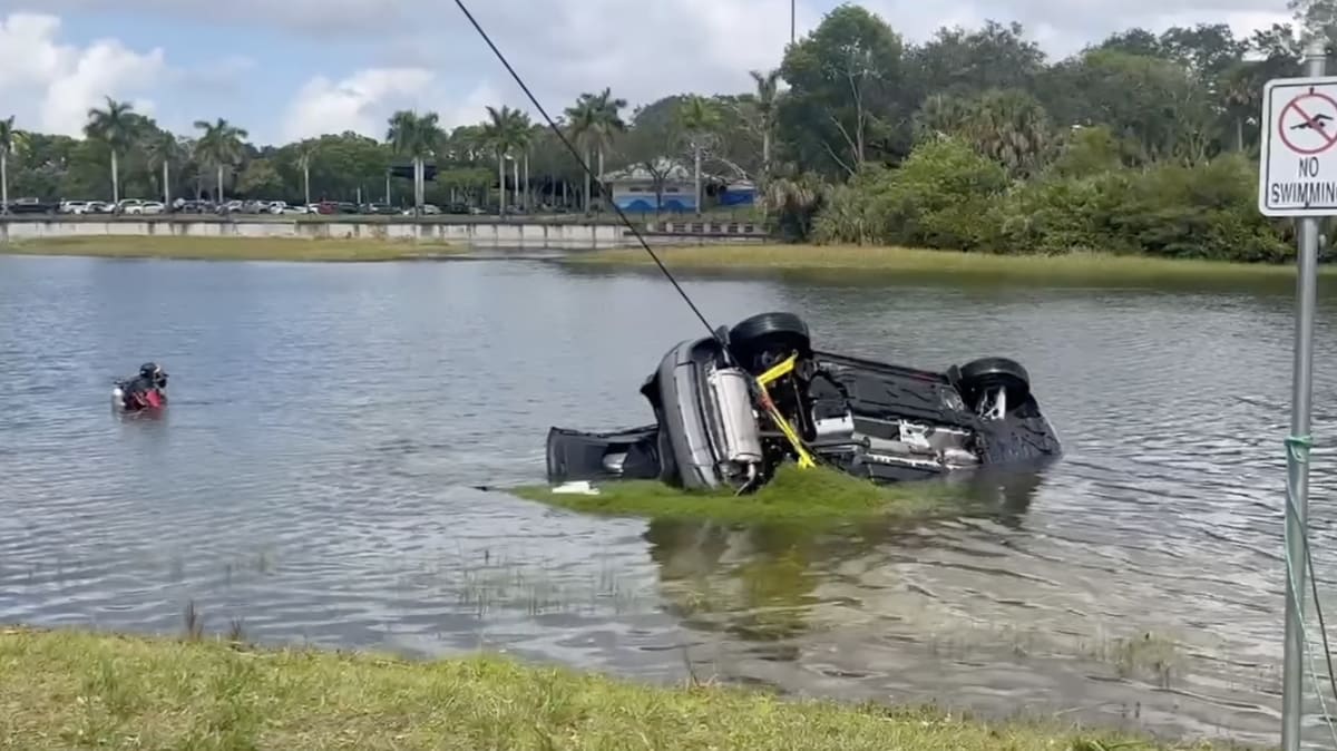 Submerged vehicle being extracted from canal by police dive team at Florida park