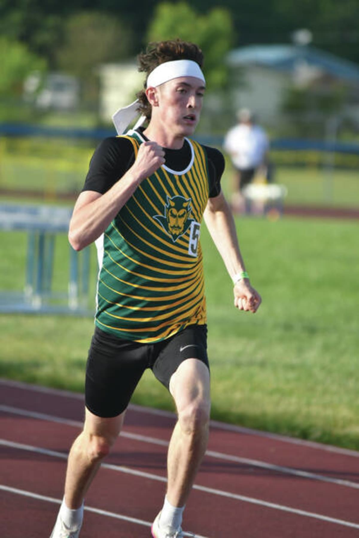 High school track athlete crossing finish line on outdoor track during championship race