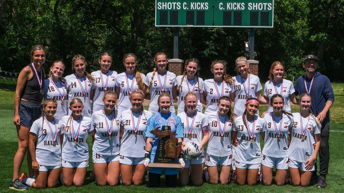 Harbor Springs High School girls soccer team celebrates with championship trophy on field