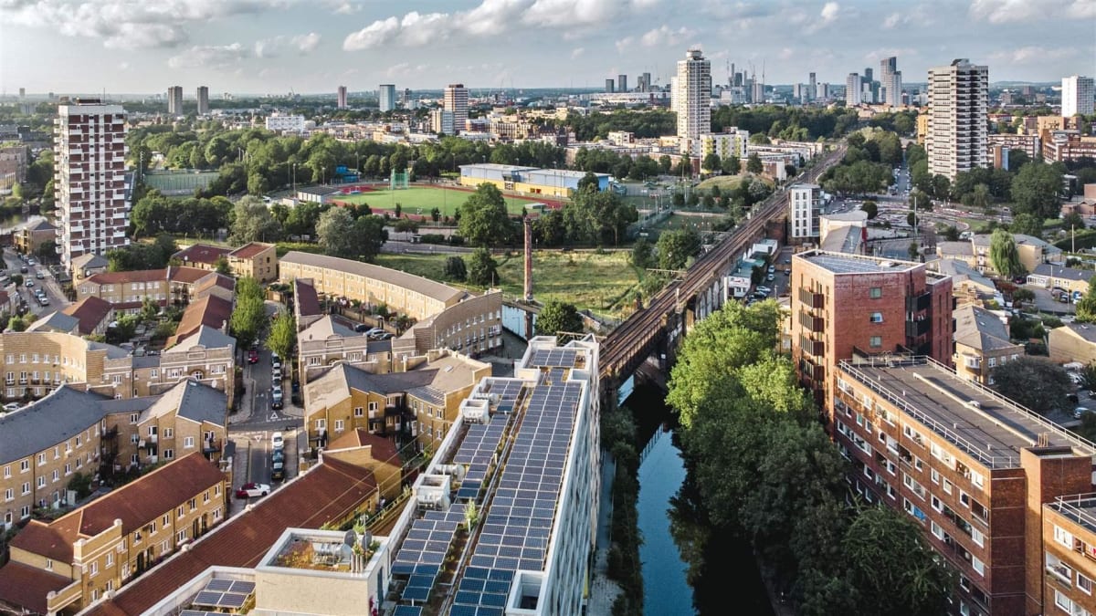 Solar panels covering rooftop of apartment building in London with blue sky background