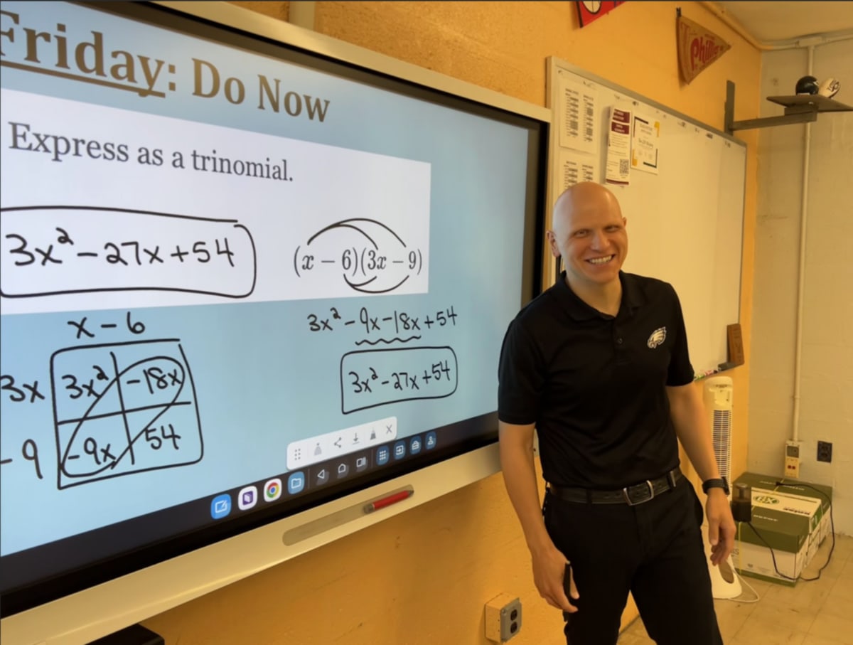 Math teacher Eric Faust smiling in his classroom at Hill-Freedman World Academy in Philadelphia