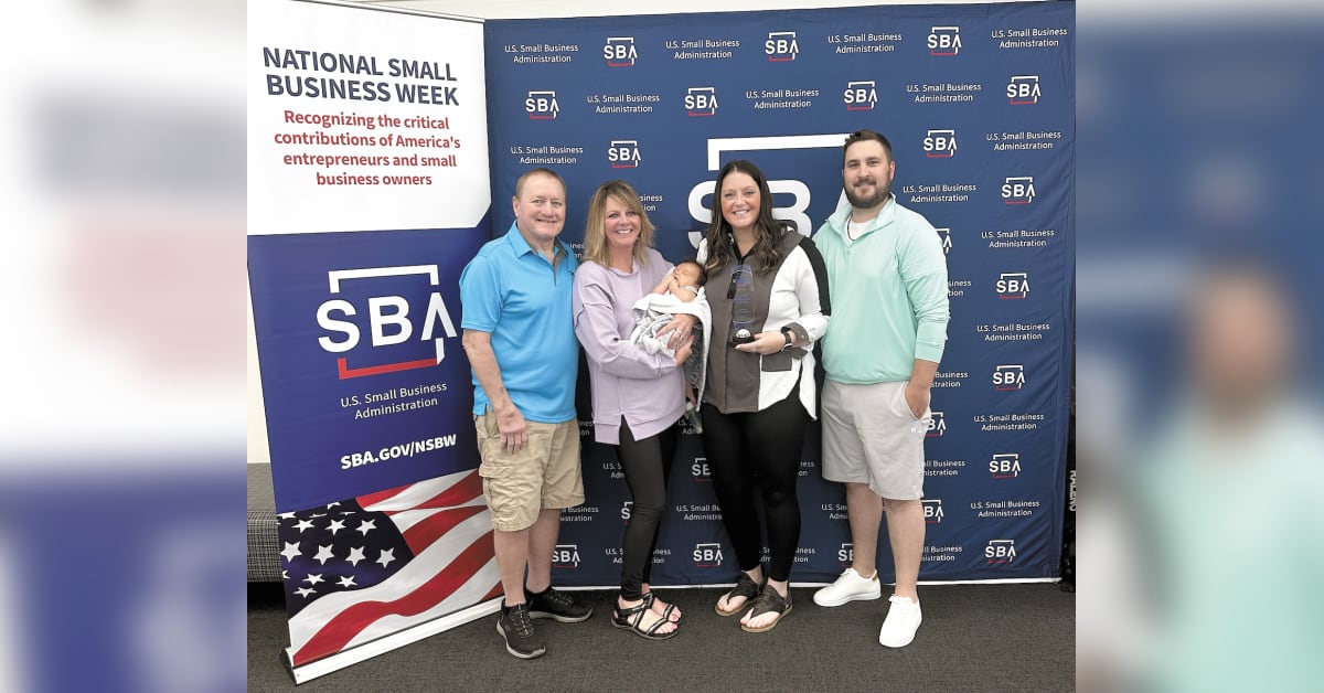 Darbi Kor holding Young Entrepreneur award with family at St. Paul RiverCentre ceremony