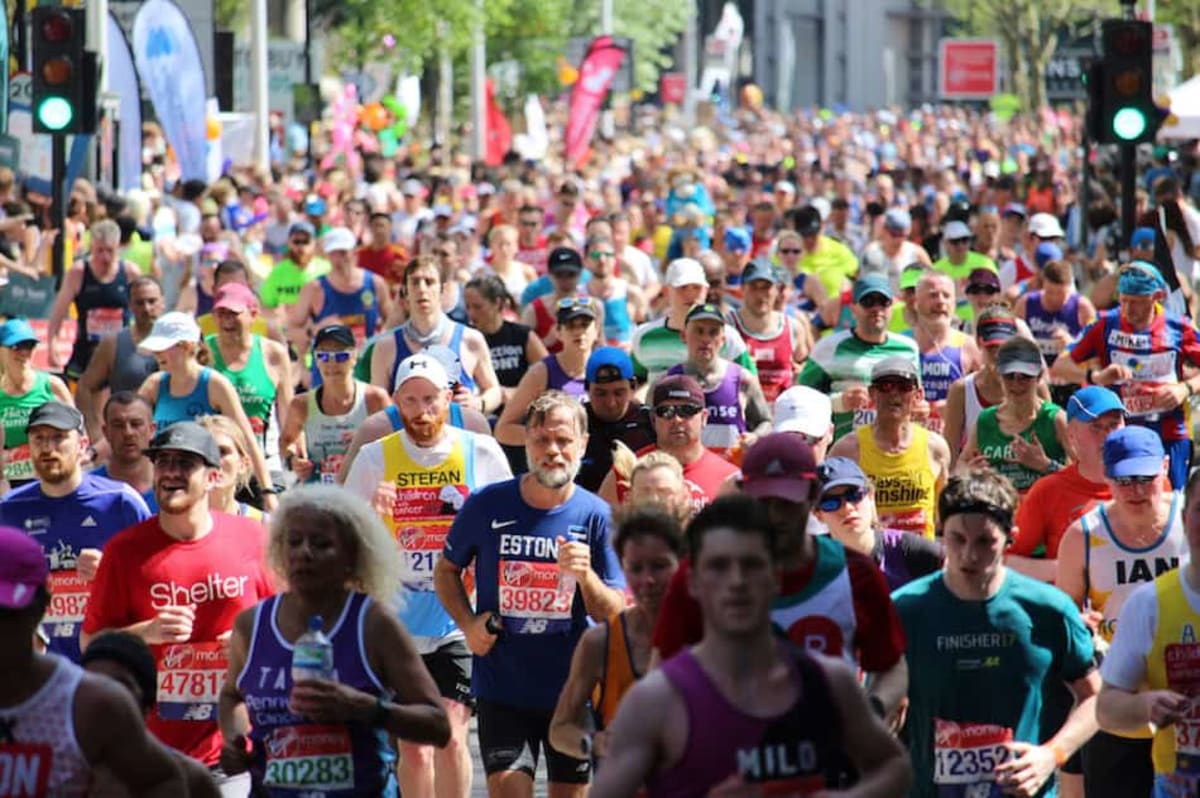 London Marathon runners in colorful costumes race past cheering crowds lining city streets