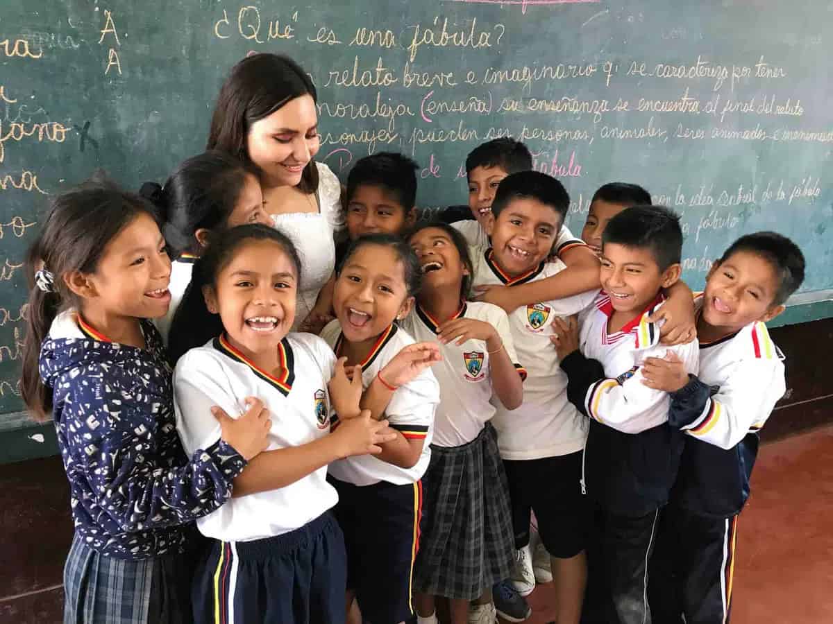Young volunteer teaching English to students in classroom in Southeast Asia