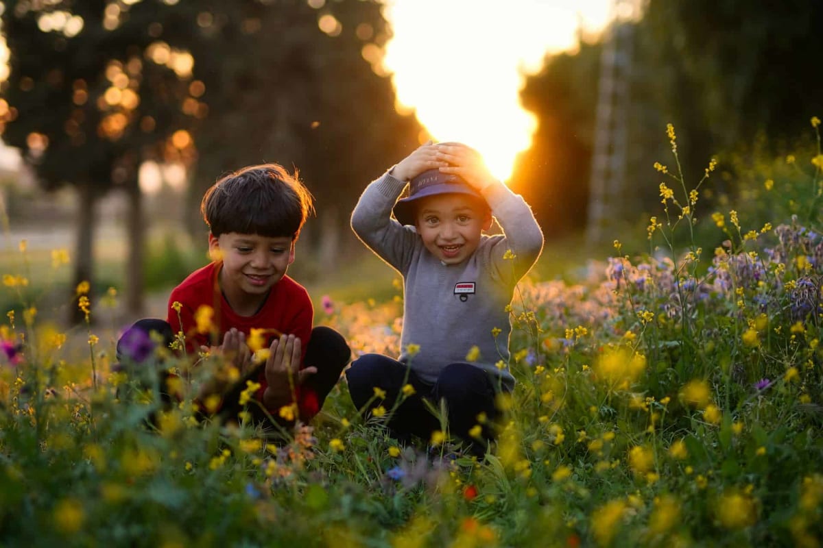 Diverse group of happy children smiling together outdoors holding hands in circle