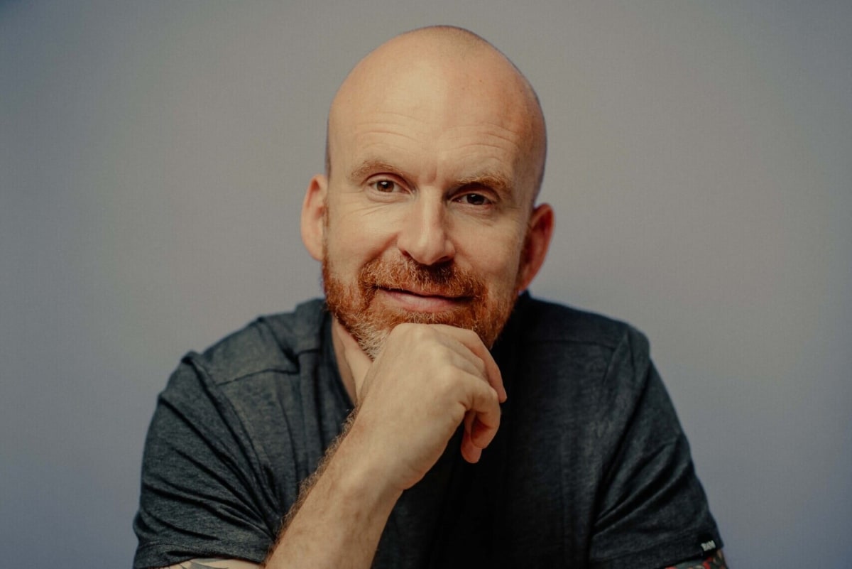 Author Matt Haig smiling warmly, best-selling writer of The Midnight Library and mental health advocate