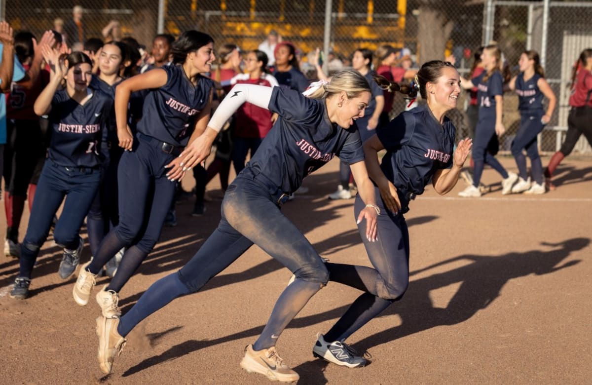 Justin-Siena softball players celebrating together after winning championship game on field