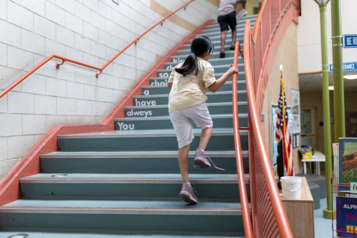 Student walking back to classroom carrying books at East End Community School in Portland, Maine