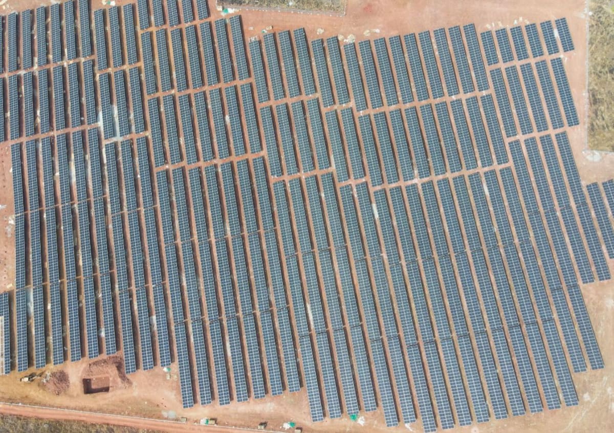 Solar panels and wind turbines stretching across Indian landscape with transmission towers