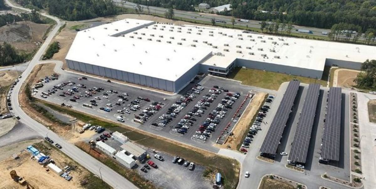 Solar panel manufacturing facility in Georgia with workers on production line assembling photovoltaic modules