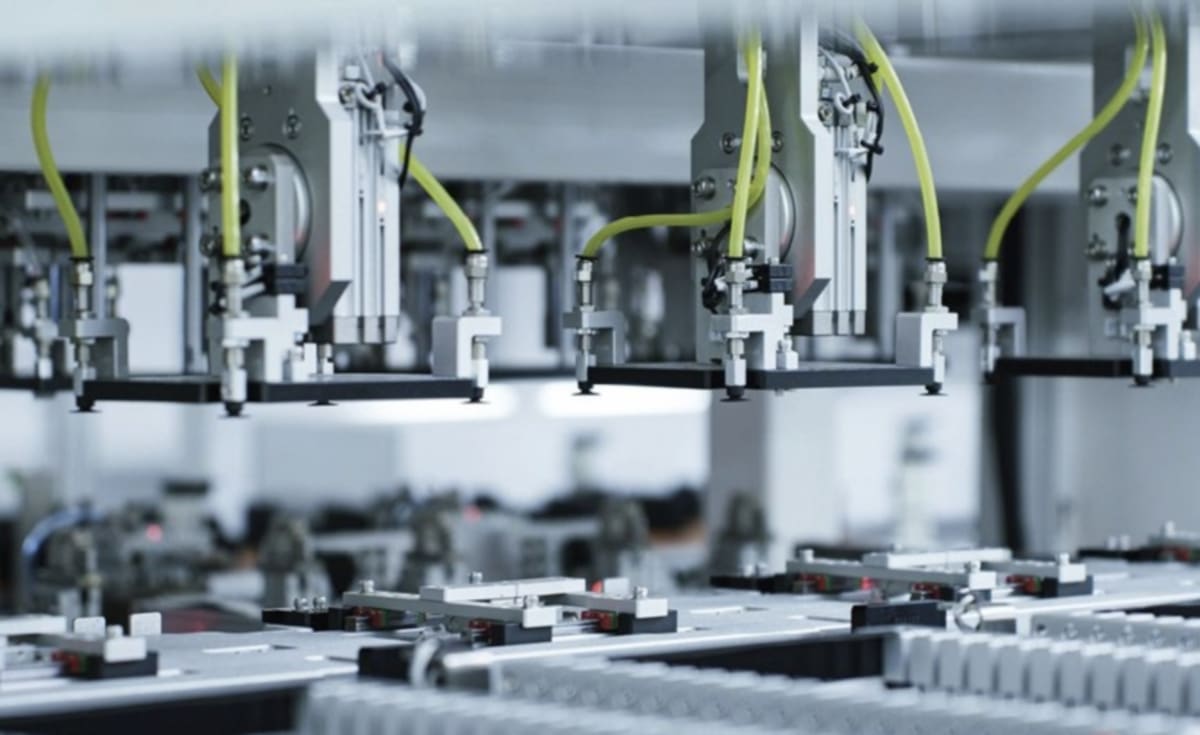 ** Modern battery manufacturing facility with rows of lithium ion cells being assembled on automated production lines