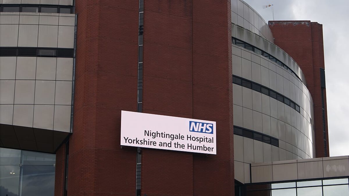 Solar panels installed on rooftop of UK school building under bright blue sky
