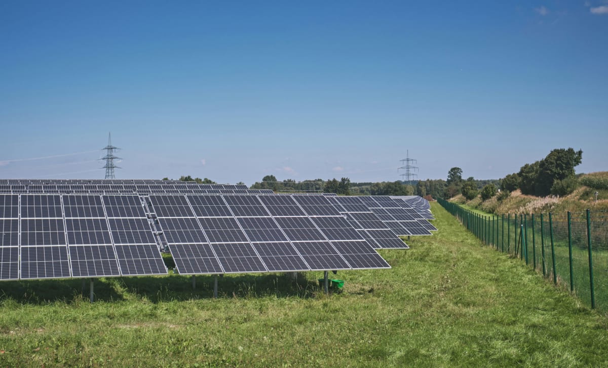 Solar panels stretching across European landscape under bright sunny sky generating renewable energy