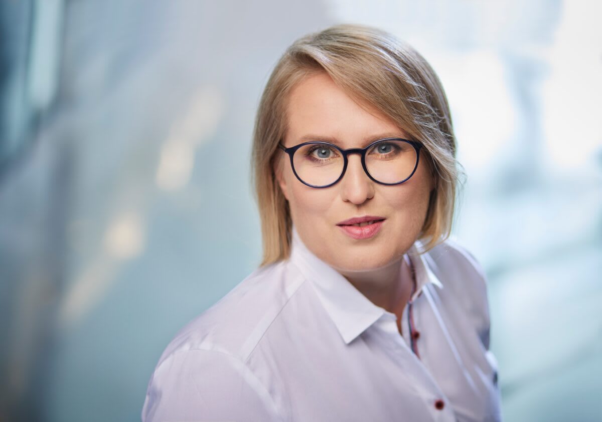 Professional woman in business setting reviewing renewable energy project documents and data