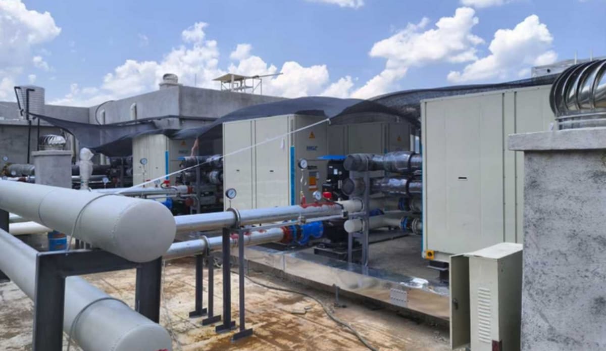 Solar panels and heat pump equipment installed on commercial building rooftop in China