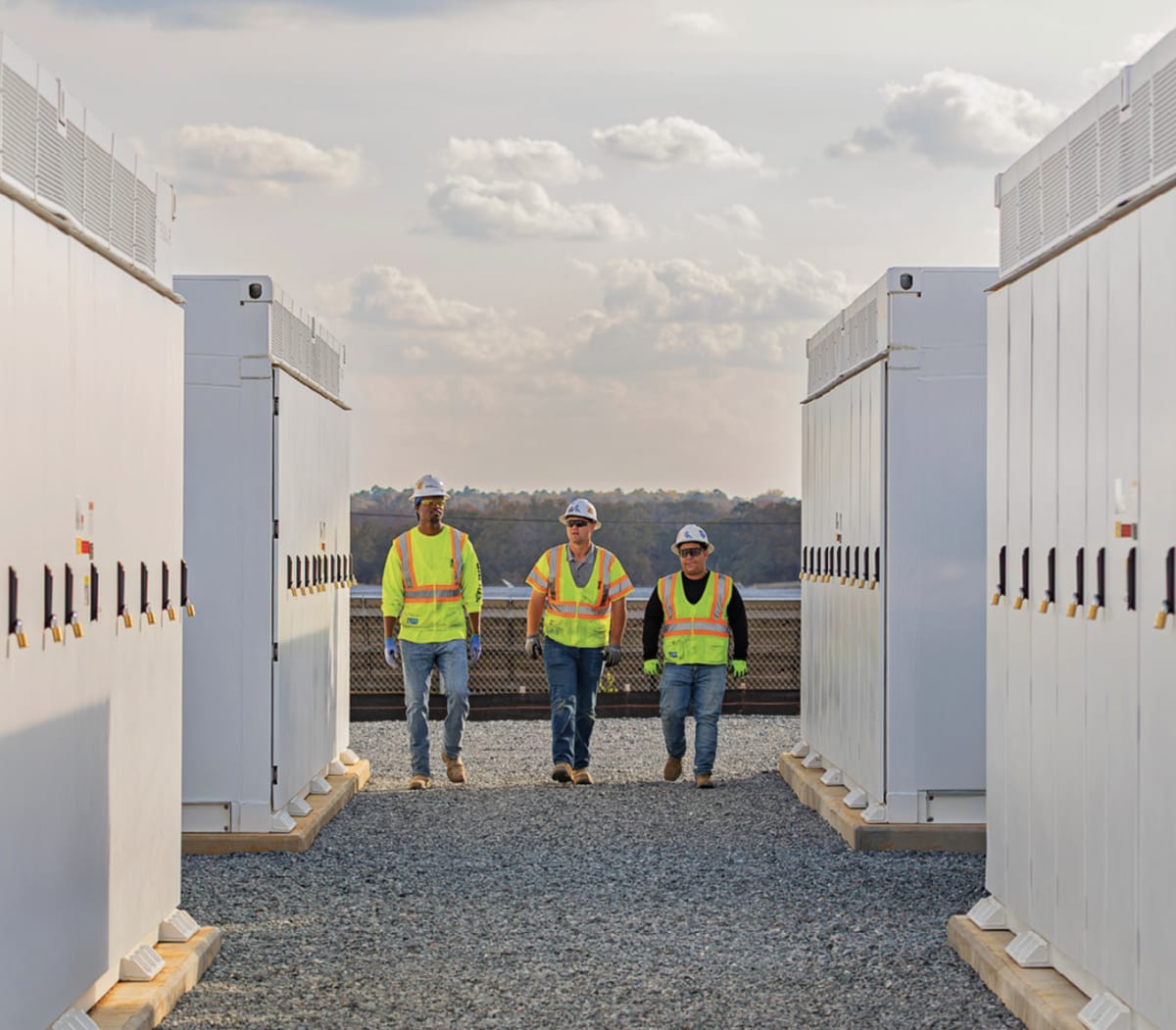 Large white battery storage units installed next to modern data center building exterior