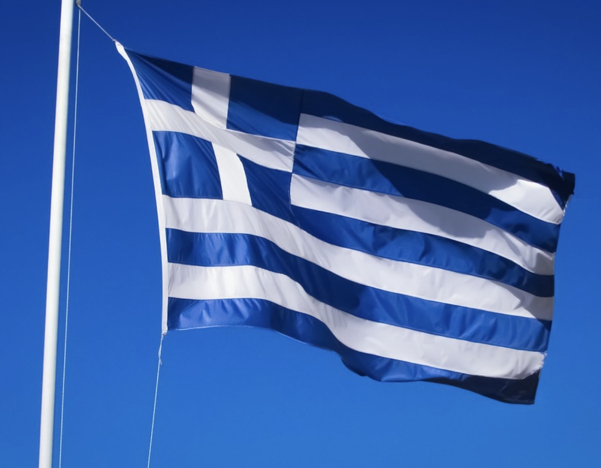 Large scale battery storage facility with solar panels under clear blue Greek sky