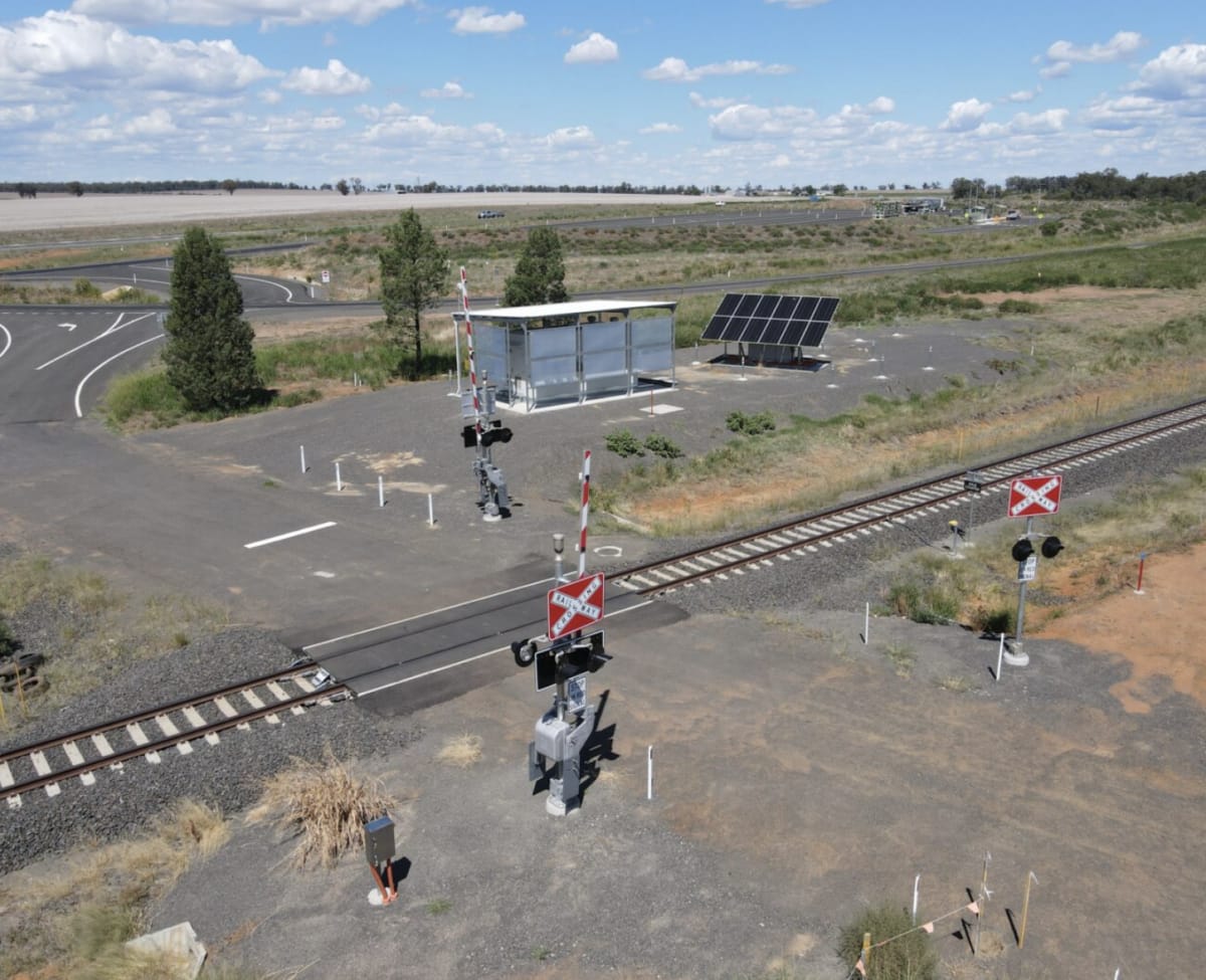 Solar panels powering railroad crossing boom gates and warning lights in rural Australia
