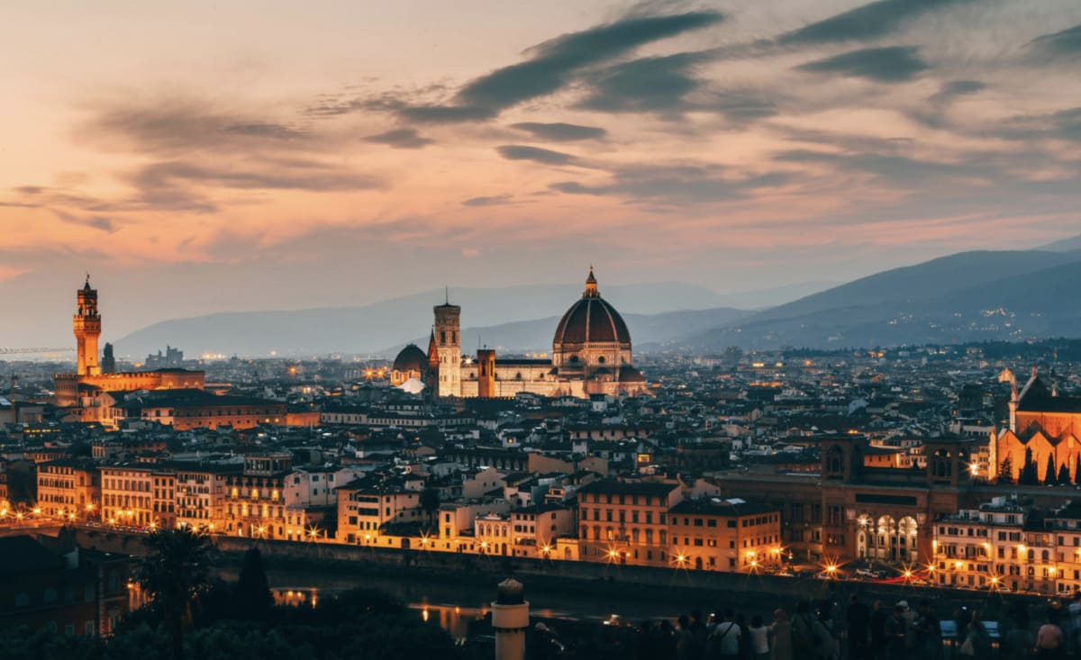 Large scale battery energy storage facility with solar panels in background at sunset