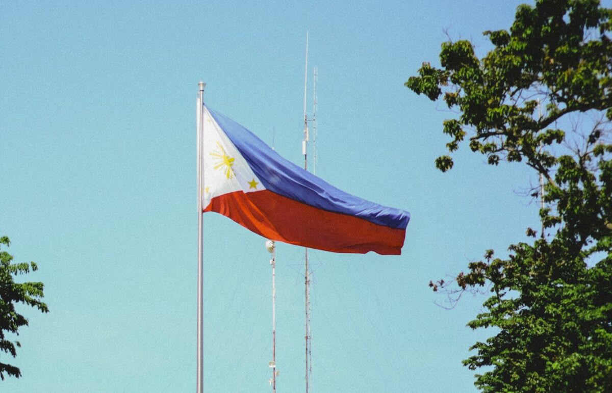 Solar panel arrays stretching across Philippine landscape under bright tropical sunshine