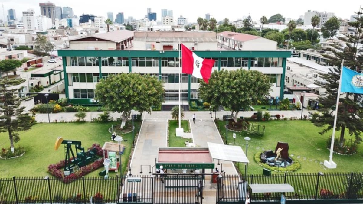 Solar panel arrays gleaming under bright Peruvian sun with Andes mountains in background
