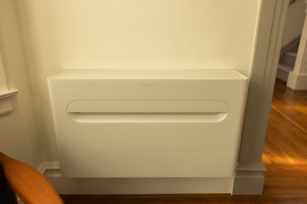 White wall-mounted indoor heat pump unit installed in modern apartment living room