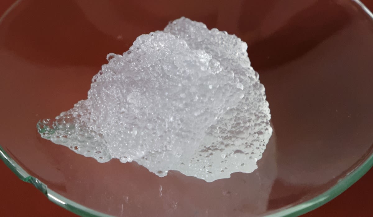 Transparent hydrogel material in laboratory setting representing water-based battery electrolyte technology innovation