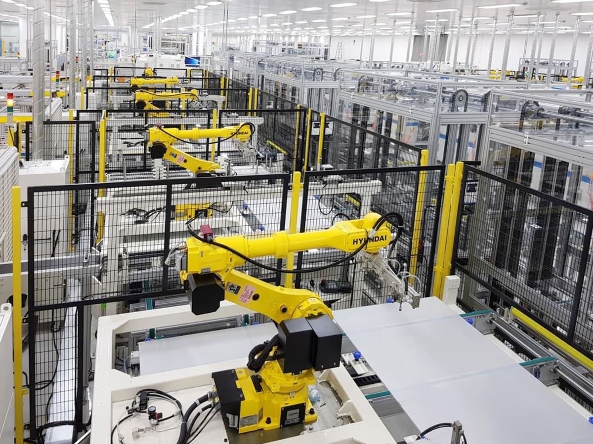 Solar panel manufacturing facility with rows of photovoltaic modules being assembled on production line