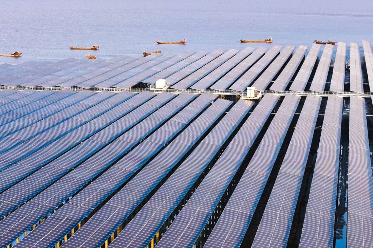 Aerial view of coastal solar panel arrays with hydrogen production facility and wetland restoration areas
