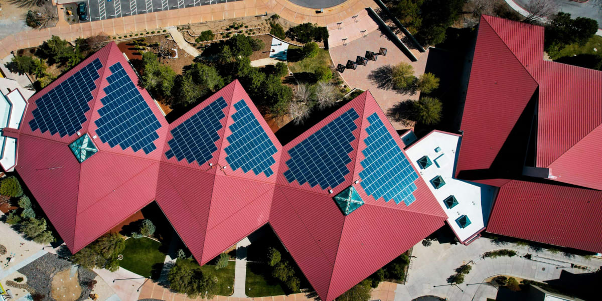 Modern home with solar panels installed on rooftop against blue sky