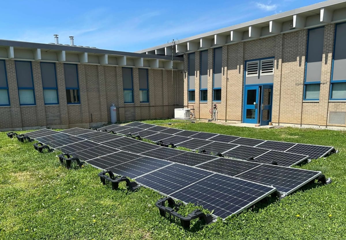 Students installing solar panels on grass racking system at Pennsylvania vocational training center