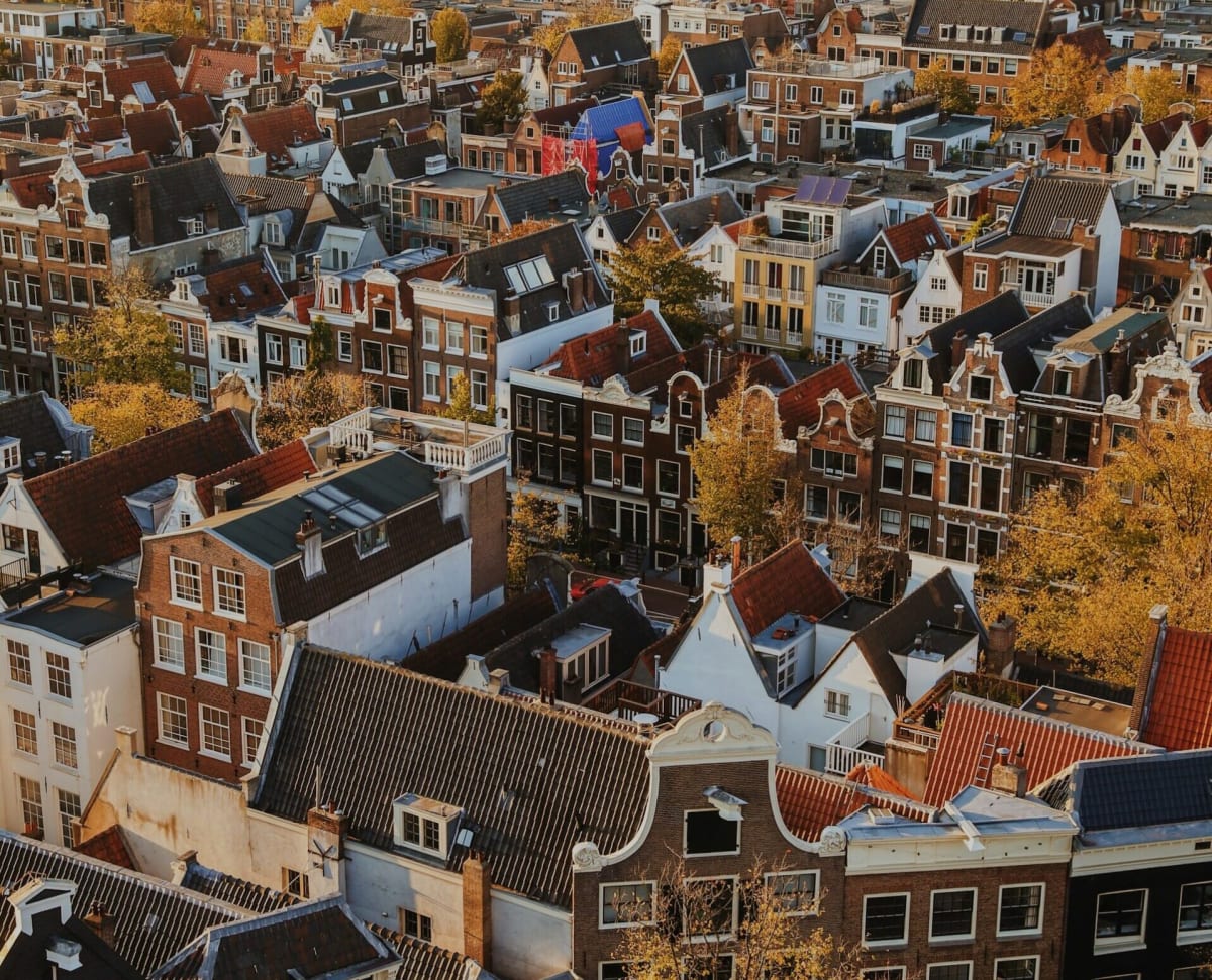 Modern solar panels installed on Amsterdam rooftop with traditional Dutch canal houses visible below