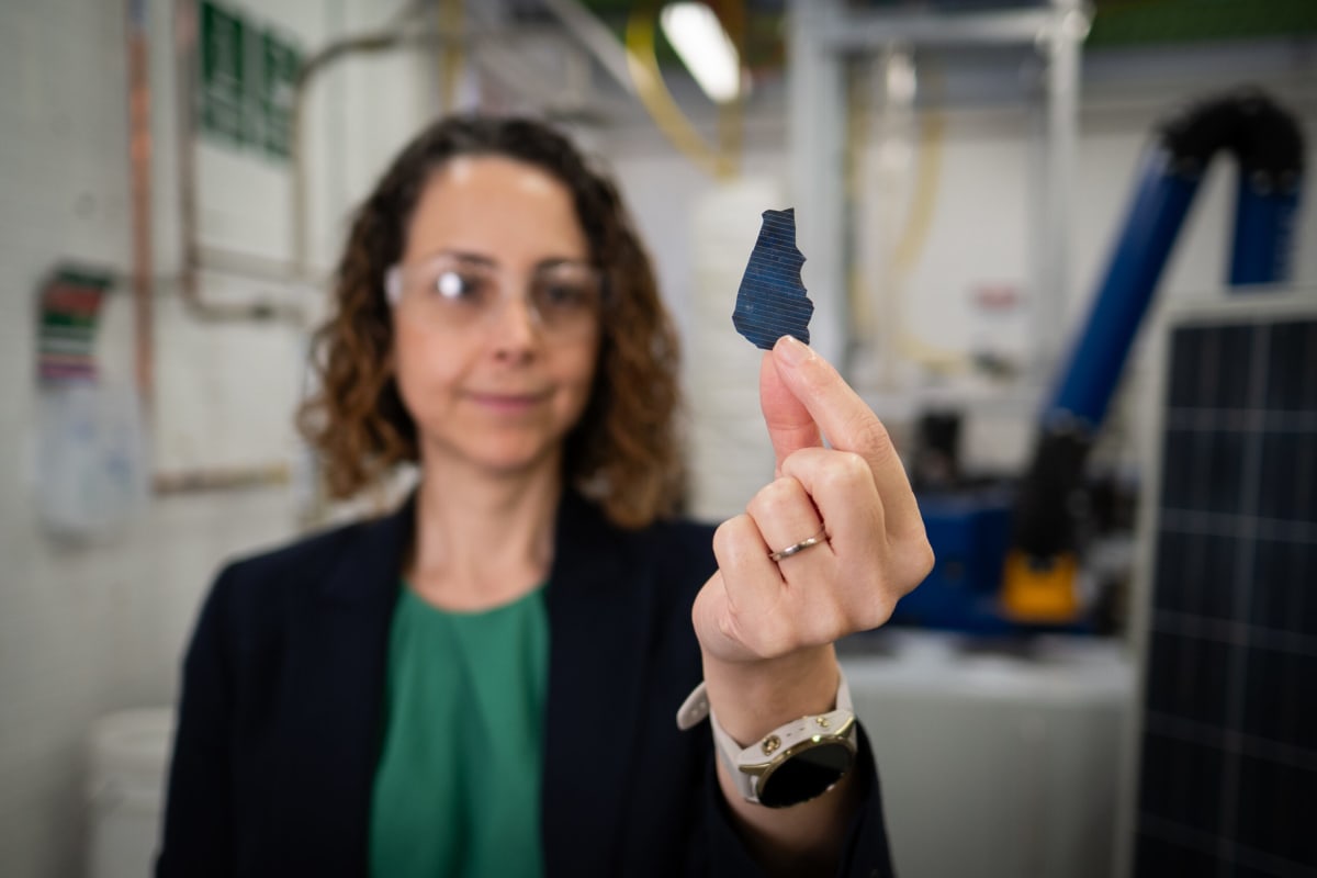 Researchers examining solar panel recycling equipment at University of Newcastle laboratory facility