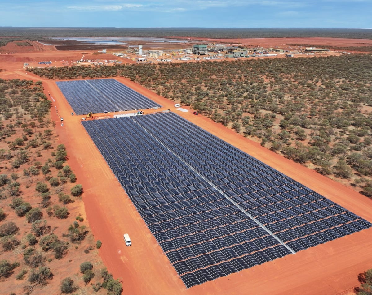 Solar panels and wind turbines powering remote mining operation in Australian outback desert