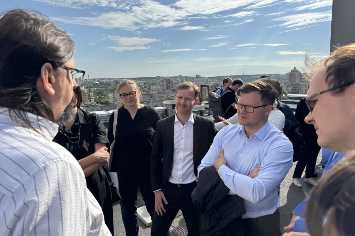 Solar panels and battery storage systems installed on Ukrainian building rooftop with blue sky