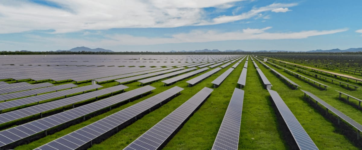 Rows of solar panels at Australian utility scale solar farm under bright blue sky